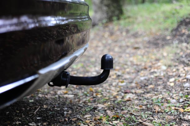 a closeup of tow bar of a car parked n the woods